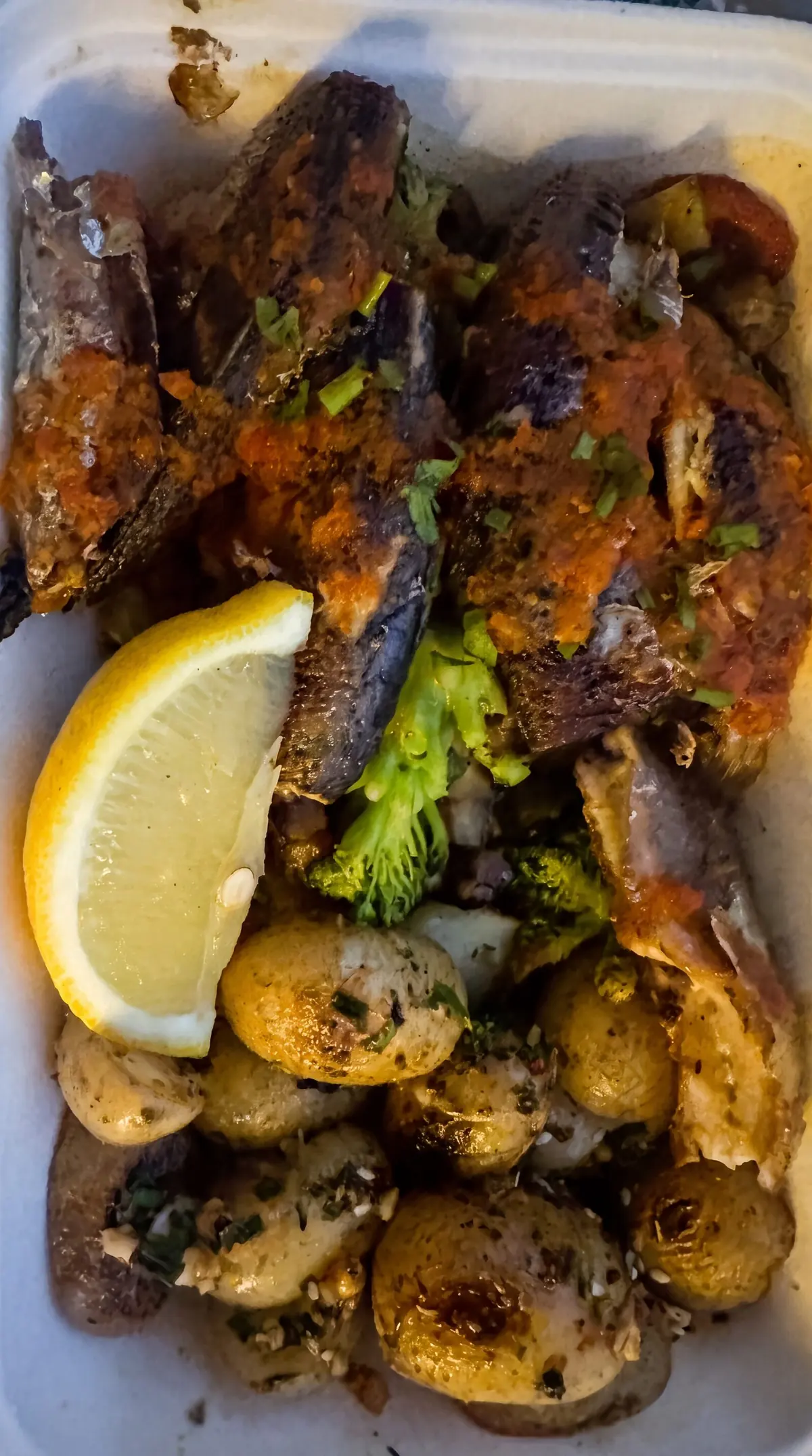 Une formule à emporter : poisson grillé à la marinade, pommes de terre sautées, brocoli et quartier de citron.
