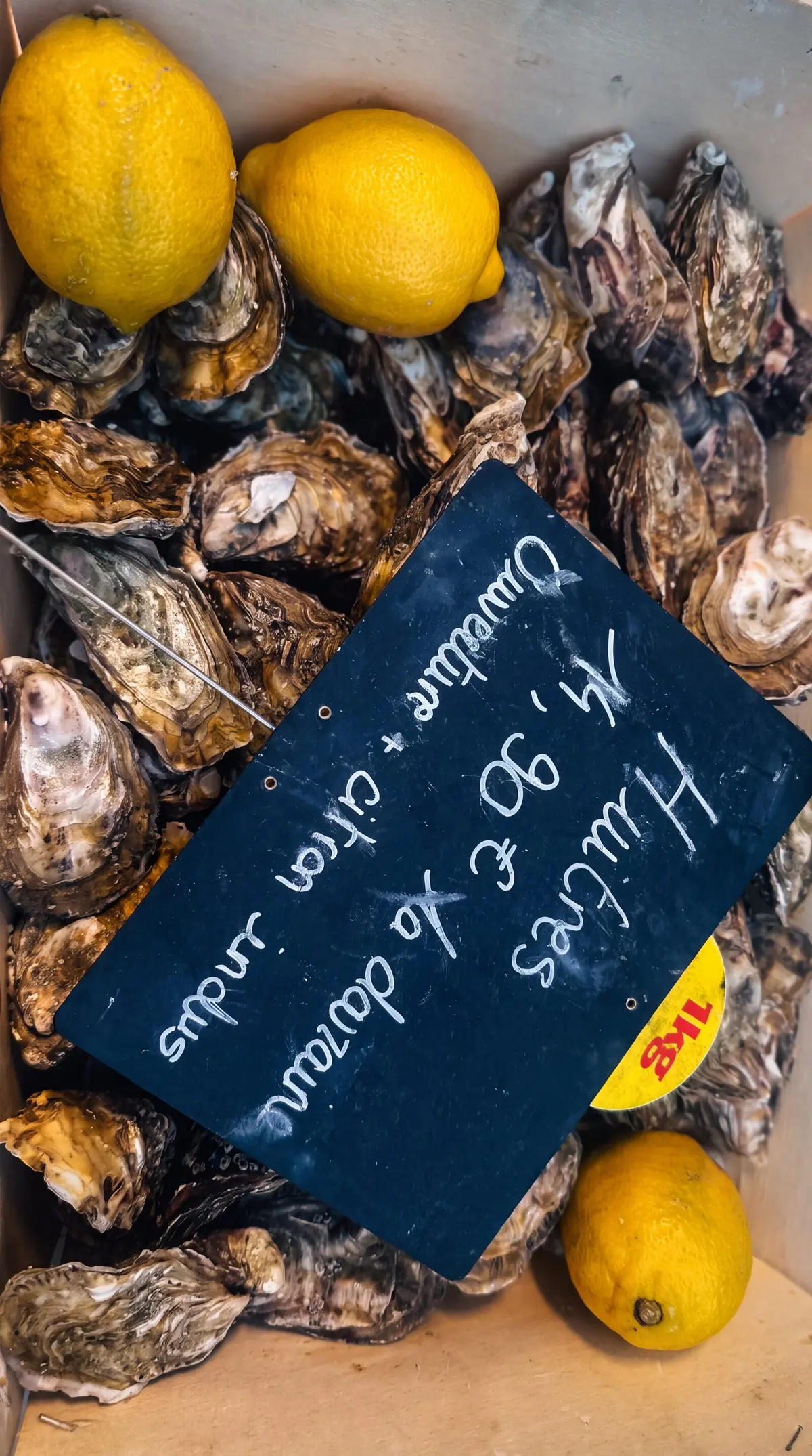 Huîtres et citrons, ardoise « 14,90 € la douzaine, ouverture et citron inclus ».